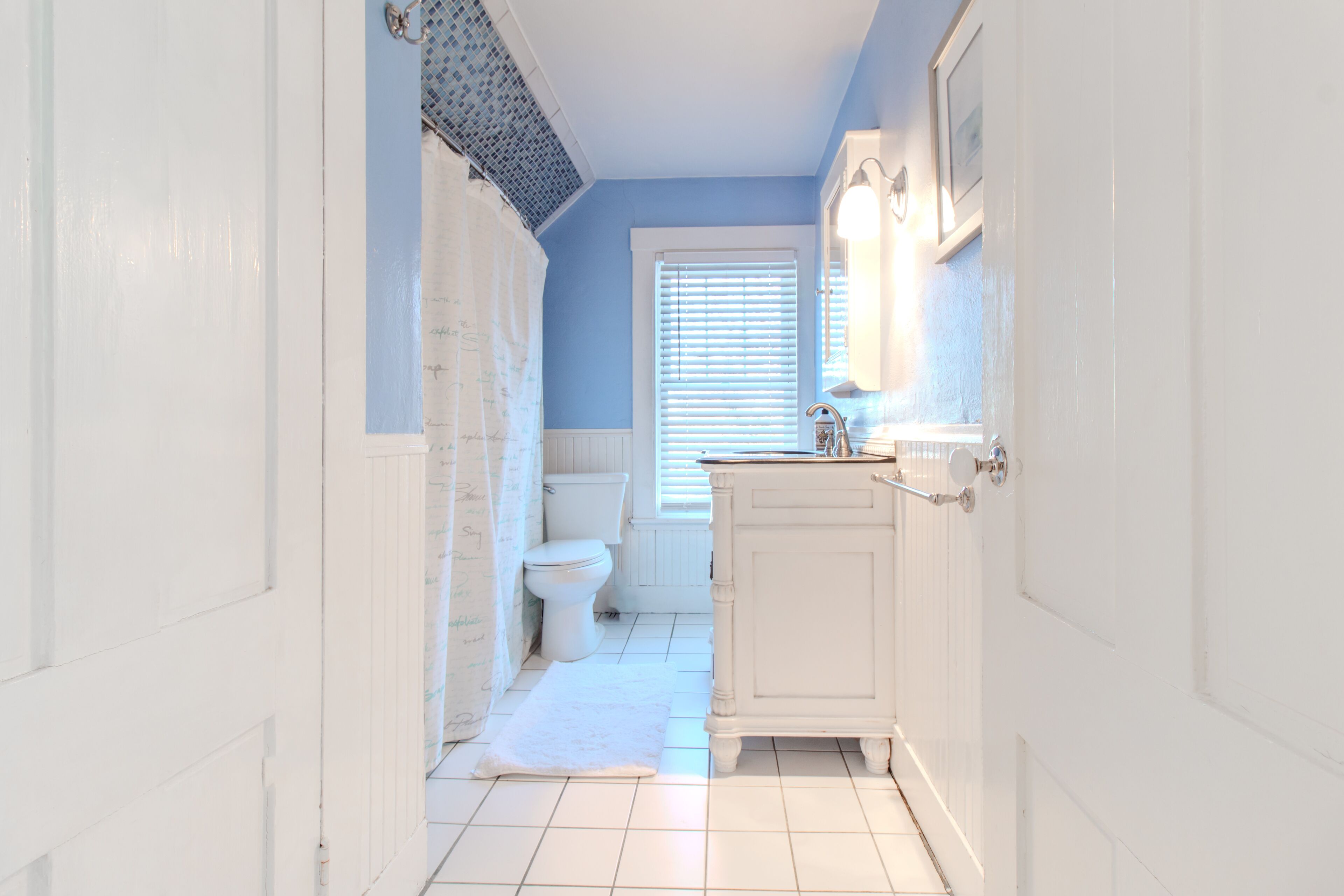 Een badkamer met toilet, wastafel en douche.