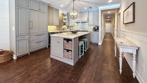 A spacious kitchen with a central island, built-in cabinets, and a long countertop.