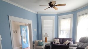 A living room with a ceiling fan, a sofa, a coffee table, and a patterned rug.