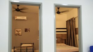 A room with a bed, an air conditioner, and a ceiling fan.