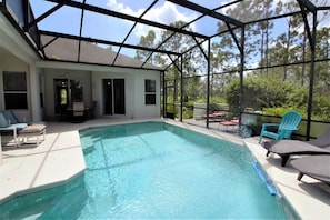 A covered swimming pool with lounge chairs and a patio area. - Beautiful 4 Bedroom Highlands Reserve Pool Home - 924NHD (Davenport)