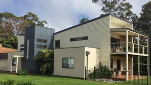 A modern two-story house with a flat roof, large windows, and a balcony. - So close to the boat ramp and beach for boating enthusiasts and beach goers!!


 (Callala Bay)