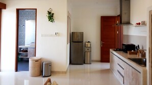 A modern kitchen with stainless steel appliances, wooden cabinets, and a tiled backsplash. - VIP Green Studio Apartment Seminyak (Kuta, Badung)