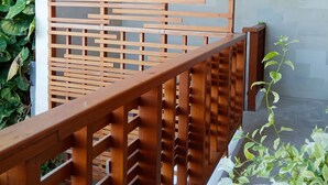 A wooden balcony railing with a geometric pattern. - VIP Green Studio Apartment Seminyak (Kuta, Badung)