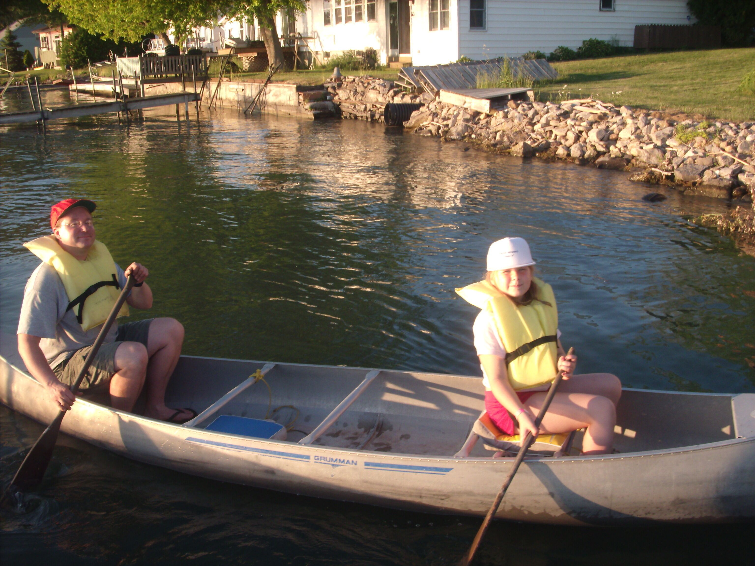 Two people in a canoe on a calm river.