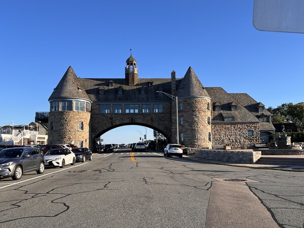 A stone archway with a tower and a large building on either side.