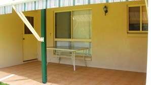 Ein Zimmer mit Fenster, Tür und einem kleinen Tisch.