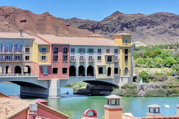 Un immeuble à plusieurs étages doté de balcons et surmonté d’un pont qui enjambe une rivière.
