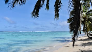Una playa cerca, sillas reclinables de playa, toallas de playa
