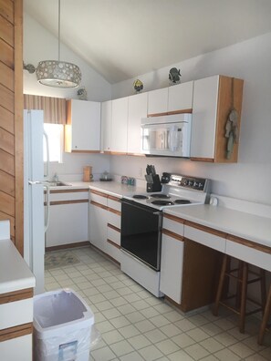 Enjoy cooking in this well-equipped kitchen with a stainless steel stove, microwave, and sink.