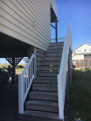 Stairs lead up to a residential building with a simple design.