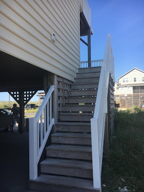 Stairs lead up to a residential building with a simple design.