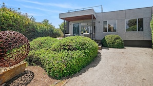 A modern building with a flat roof, large windows, and a covered outdoor area. - Sirocco Roof Top Deck Pet Friendly in Aireys Inlet (Aireys Inlet)