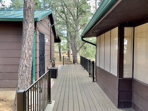 Guests can enjoy a deck with a railing, offering a view of the surrounding trees.