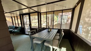 A covered outdoor seating area with a table and chairs, a view of the outdoors, and a pergola structure. - Cozy Cabin: Deck, Hot Tub, Views & Starry Nights (Prescott)