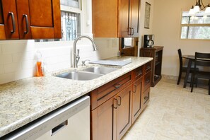Enjoy cooking in this well-equipped kitchen with a double sink, coffee maker, and dining area.