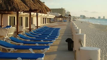 Rannalla, aurinkotuoleja, rantapyyhkeitä