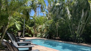 A pool area with lounge chairs and a clear blue pool surrounded by lush tropical vegetation. -  Steps to the Beach and a Stroll to Fort Lauderdale Nightlife  (Fort Lauderdale)