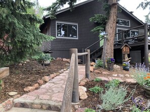 Stroll through the beautifully maintained garden, featuring a variety of plants and flowers, and a charming wooden fence.