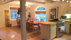 A kitchen with wooden cabinets, a central island, and a dining area with chairs and a table. - 5 Bdrm Lakehouse, sleeps 18, private dock, hot tub, 15 minutes to Mount Snow (Wilmington)