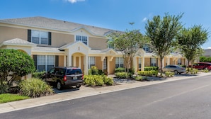 A row of townhouses with a clear driveway, a parked SUV, and a red car. - Updated Furniture, 2 Miles To Disney, 3 BD, 3 BA, Private Pool, 5 Stars Resort, (Kissimmee)