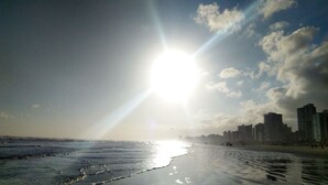 Una playa con el perfil urbano de una ciudad al fondo.