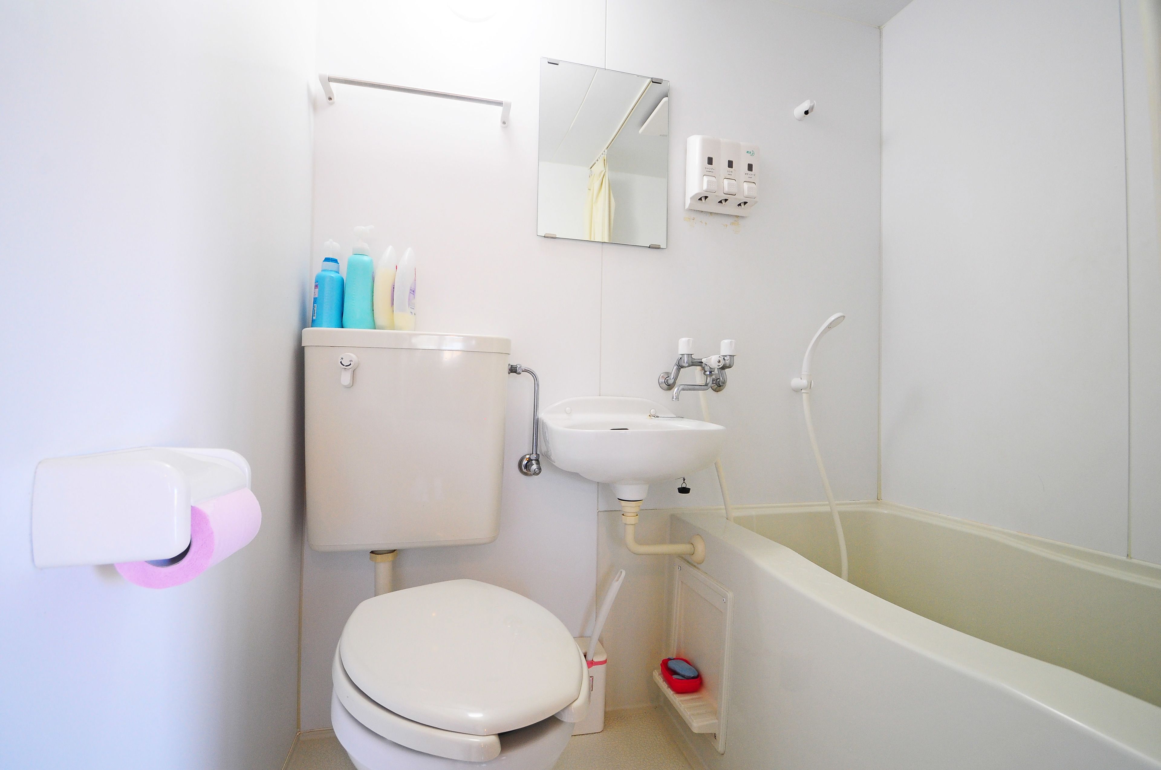 Et badeværelse med toilet, håndvask og badekar.