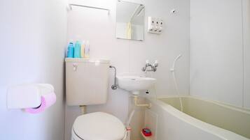 Et badeværelse med toilet, håndvask og badekar.