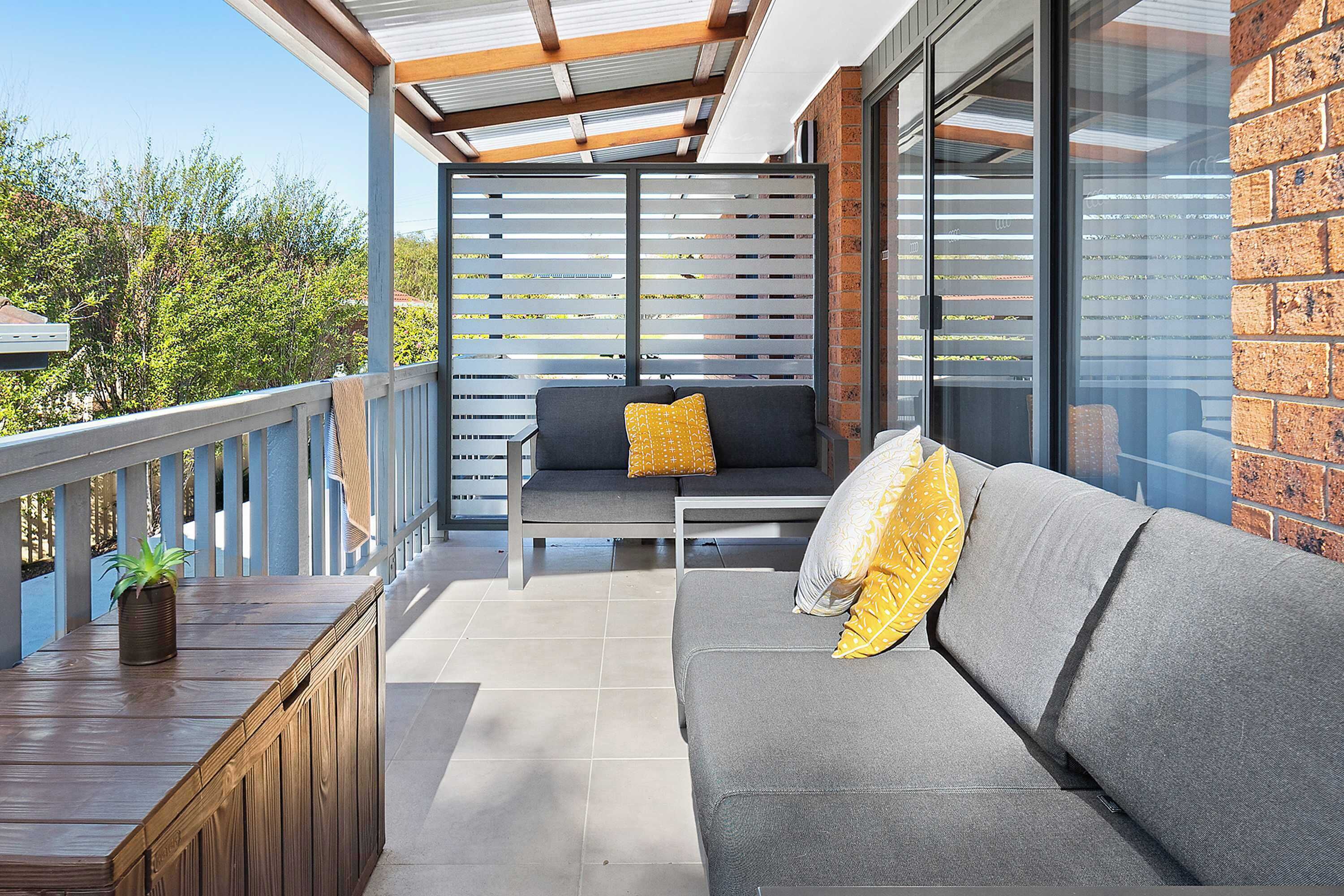 Spacious covered rear patio with outdoor furnishings and bbq