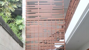 A modern indoor pool area with a wooden staircase and potted plants. - Green Studio Seminyak (Kuta)