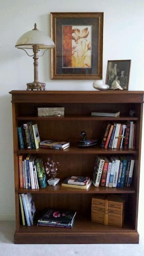 Cozy reading nook with a bookshelf and table lamp.