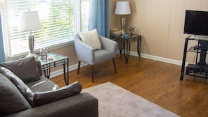 A living room with a sofa, armchair, and a television. There is a window with blinds, a lamp, and a small table with a decorative item. - Stay Where The Stars Stay! And we think everyone who stays with us is a STAR! (Nashville)