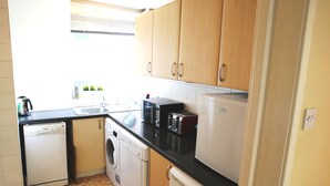 A compact kitchen with a dishwasher, washing machine, microwave, toaster, and refrigerator. - Beautiful 2 Bedroom Private Apartment (London)