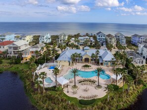 Enjoy a scenic ocean view from the pool deck, surrounded by lush greenery and multi-story buildings.