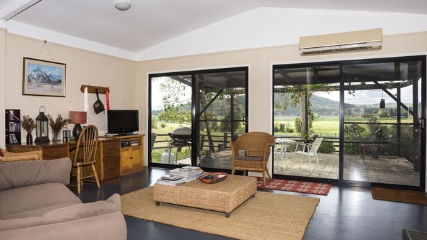 A spacious living room with a large sliding glass door leading to an outdoor patio.