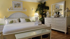 Un dormitorio con cama, mesitas de noche, cómoda y espejo.