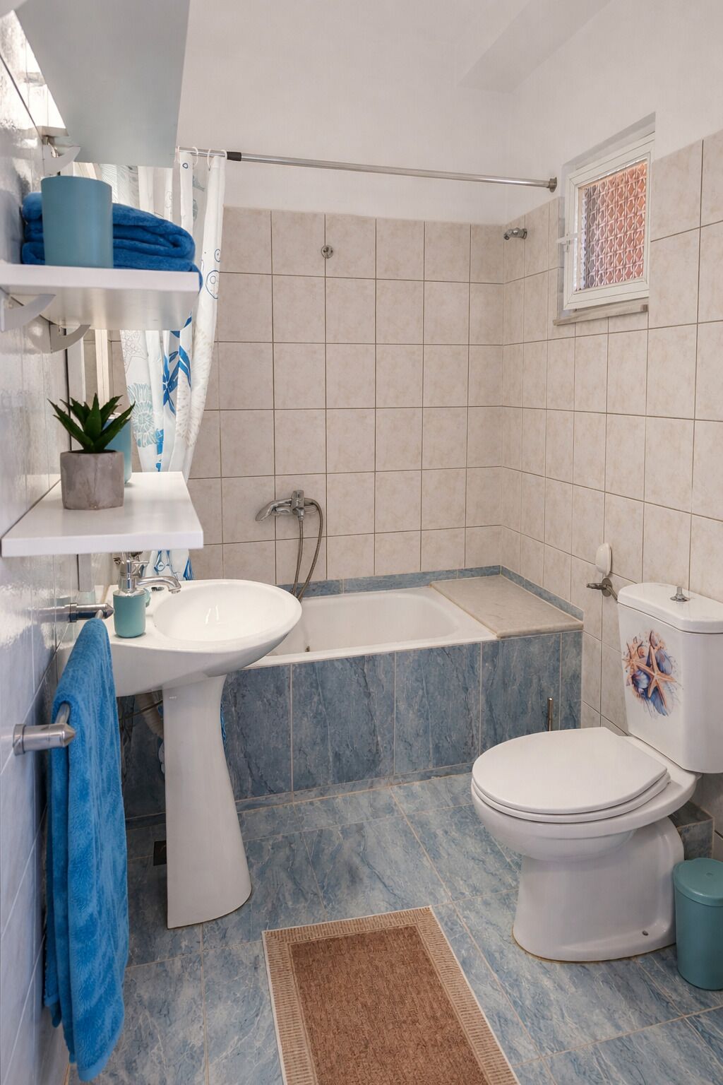 A bathroom with a sink, bathtub, toilet, and a shower curtain.