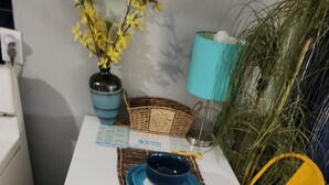 Een eettafel met blauwe borden en kommen, een vaas met gele bloemen en een mand met een hartmotief.
