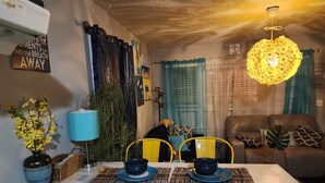 Een eethoek met een witte tafel, blauwe stoelen en een blauwe lamp.