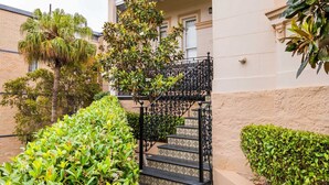 A building with a checkered floor, a black metal staircase, and a balcony with a decorative railing. - Quiet Glebe Studio Near Parks & Cafés (Glebe)