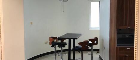 Une cuisine moderne avec un coin repas, un ventilateur de plafond et des armoires en bois.