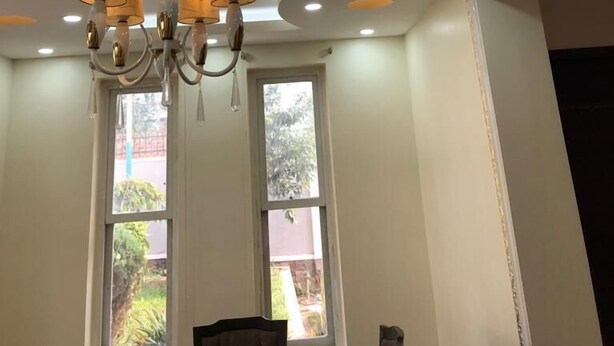 A room with a modern chandelier, recessed ceiling lights, and large windows. - Beautiful two-level, fully furnished 4 bedroom house with WiFi (Kampala)