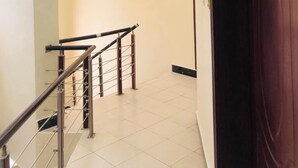 A modern interior with a staircase, recessed ceiling lights, and a wooden door. - Beautiful two-level, fully furnished 4 bedroom house with WiFi (Kampala)