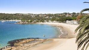 A coastal beach with clear waters, a sandy shore, and a backdrop of residential buildings. - Balmoral Beauty - DIRECT BEACHFRONT - Romantic Studio Escape (Mosman)
