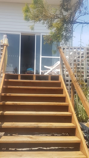 A wooden staircase leading to a building with large windows. - Stunning water views. Direct bayside access. Free WIFI. Dark sky viewing. (Stieglitz)