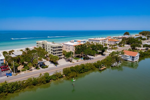 An aerial view of a coastal town with buildings, a road, and a body of water.