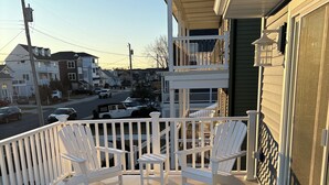 A covered porch with white railings and two white Adirondack chairs. - Beautiful & Newly Renovated, 6 Br, 4 Bath,Open floor plan  (Brigantine)