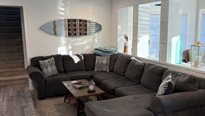 A modern living room with a sectional sofa, a coffee table, and a ceiling fan. - Beautiful & Newly Renovated, 6 Br, 4 Bath,Open floor plan  (Brigantine)