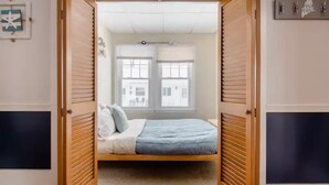 A bedroom with a bed, a window, and a door. - Adorable Beach House Across the Street From Beach! (Scarborough)