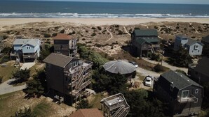 Un área residencial costera con casas, una playa y vista al océano.
